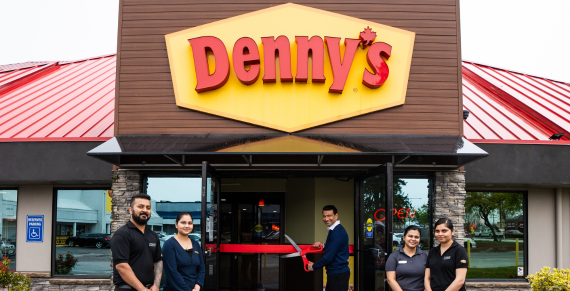 Denny's employees and store owner standing outside of Denny's location for grand opening