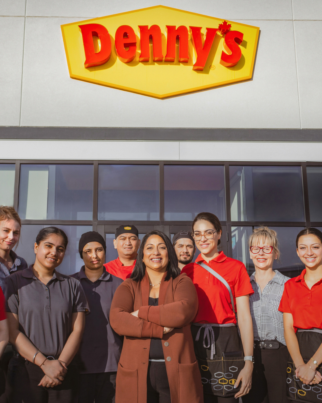 Denny's franchisee standing outside of a Denny's location with team